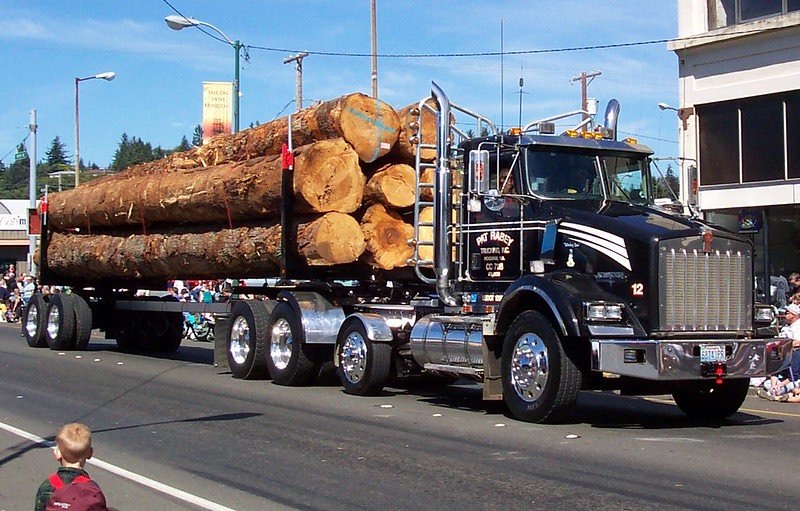 Loaded logging truck driving through a city street